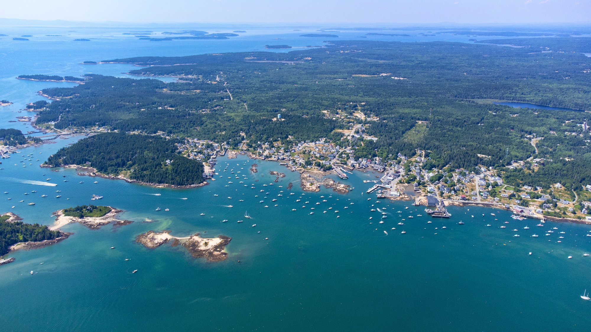 Stonington arial view of town and harbor and islands. Boat tours in Stonington, Maine. Ocean activities. Charters. Swimming. Penobscot Bay. Maine life.